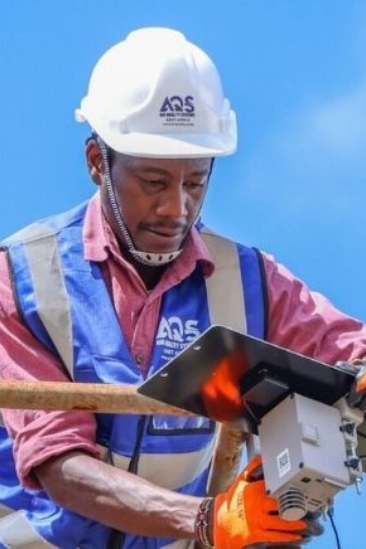 AQS engineer installing air quality monitoring equipment at an industrial site in Kenya.